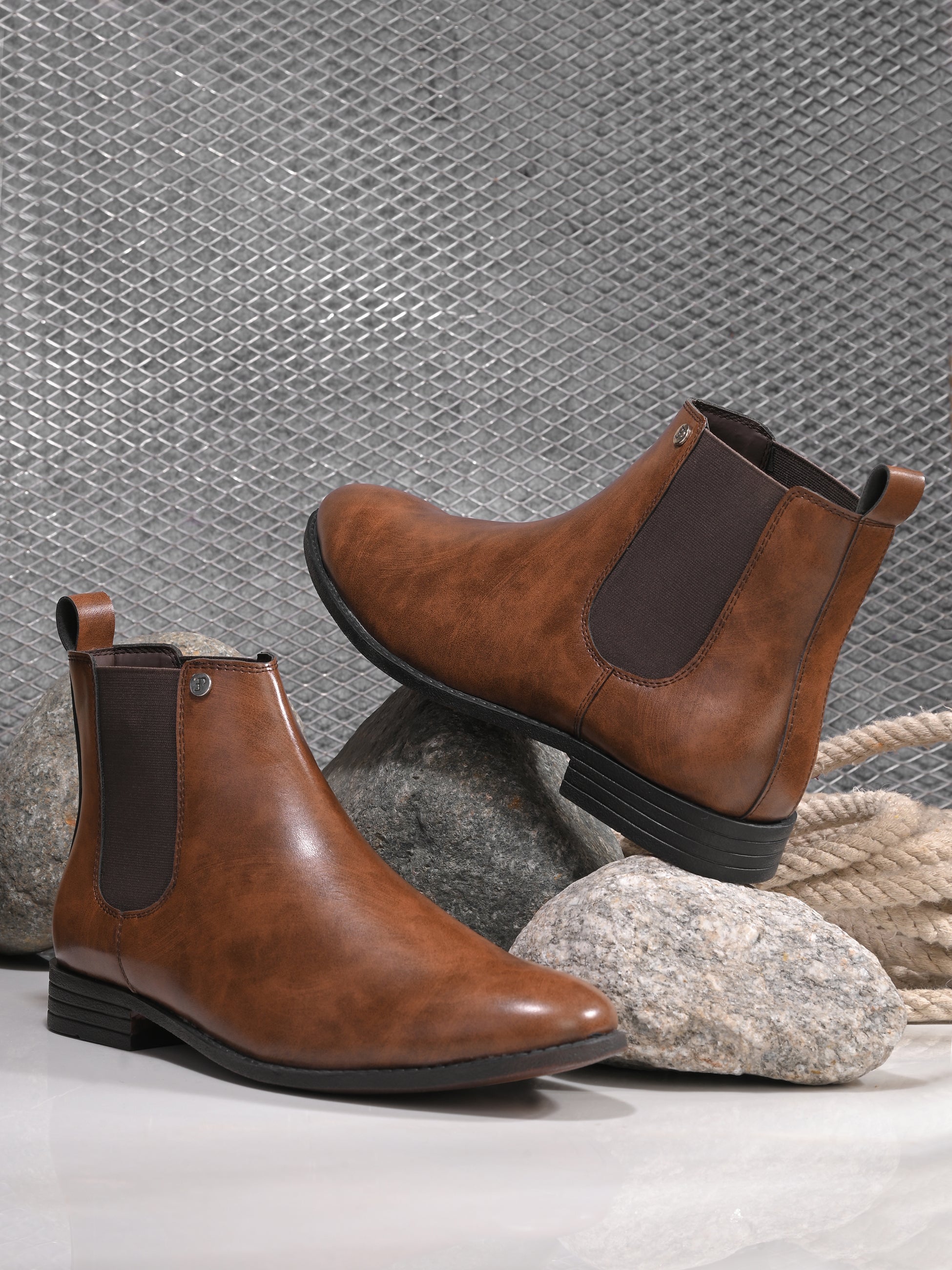 A sleek brown leather boot with elastic side panels, pull tab, low stacked heel, and a polished finish for a versatile look.