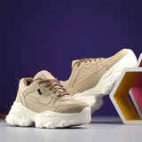 Beige chunky sneaker with a textured white sole, brown laces, and modern detailing, designed for casual and stylish wear.