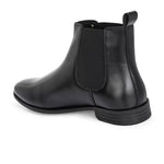 A sleek black leather Chelsea boot for women with elastic side panels, pull tab, low stacked heel, and a polished finish for a versatile look.