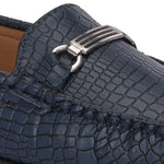 A stylish navy-blue loafer with a textured crocodile-pattern design, featuring a metallic buckle detail on the upper and colorful accents on the outsole.