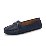 A stylish navy-blue loafer with a textured crocodile-pattern design, featuring a metallic buckle detail on the upper and colorful accents on the outsole.