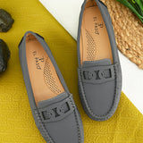 A gray loafer for women with textured stitching and a decorative strap across the top, viewed from the side.