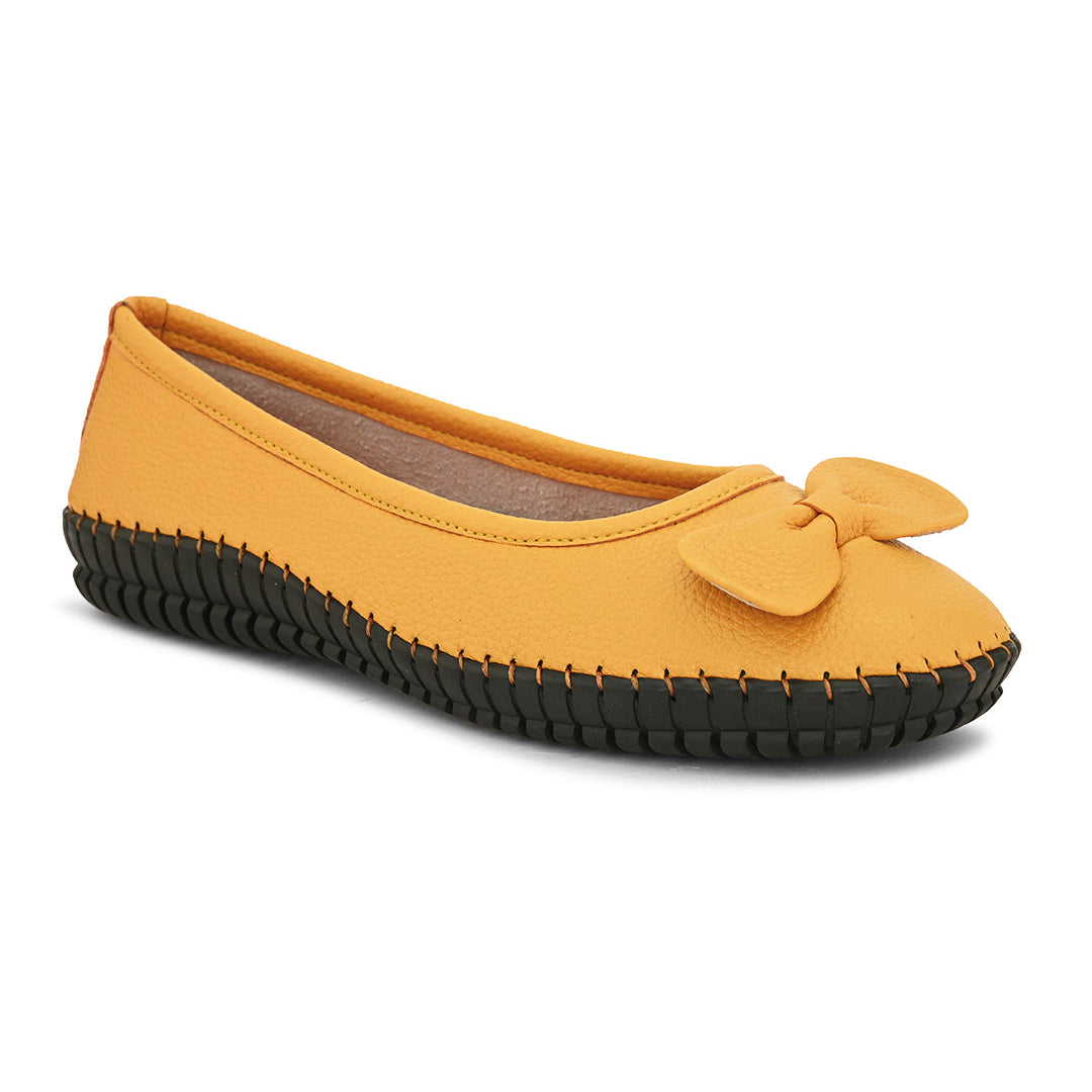 Mustard yellow leather Women Ballerina Flats with a decorative bow, black textured sole, and visible stitching for a casual, stylish look.
