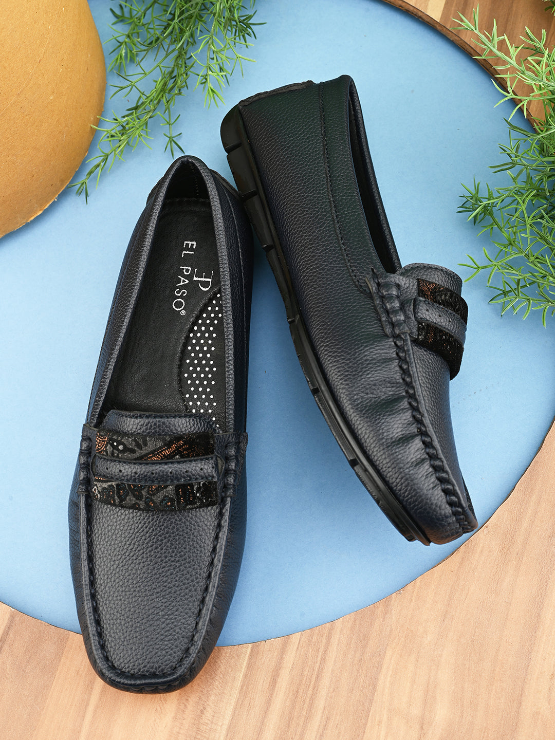 A single dark gray leather sleek loafer for women with a textured sole and decorative strap across the front.